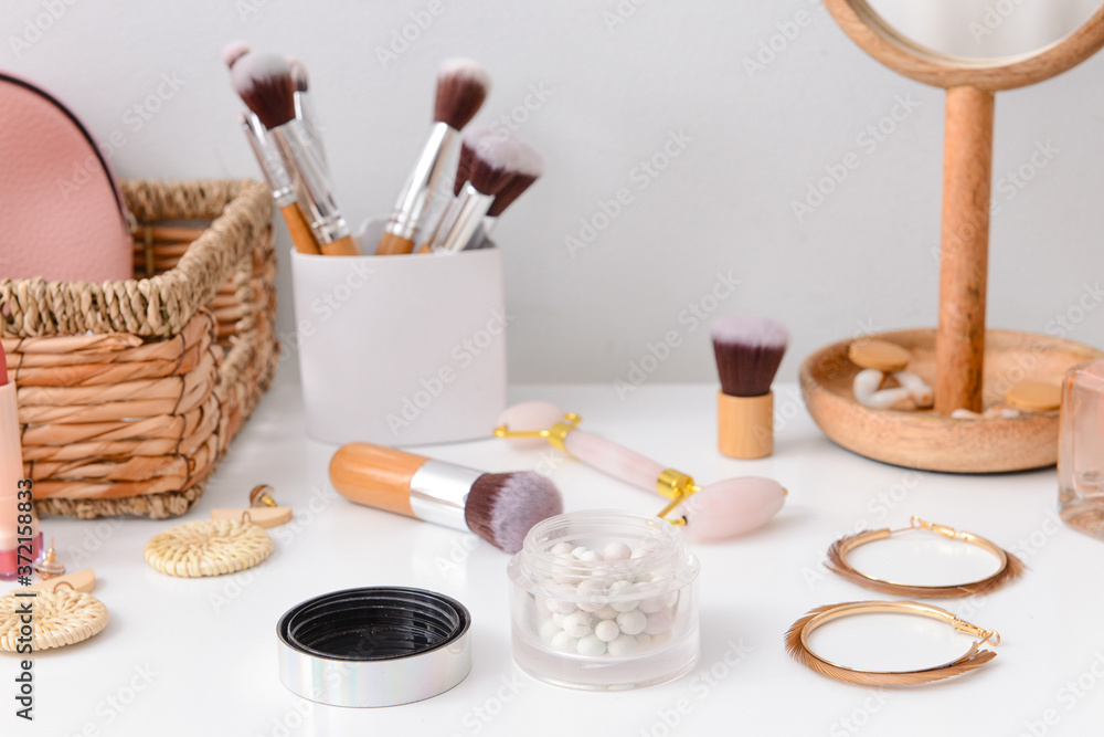 Set of decorative cosmetics with jewelry on dressing table