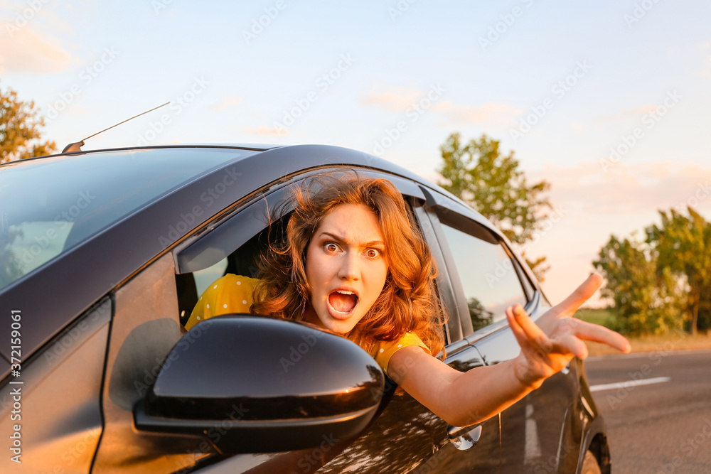 Stressed young woman sitting in car