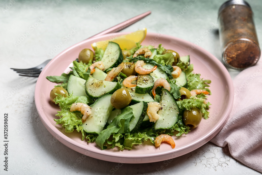 Plate with tasty cucumber salad on light background