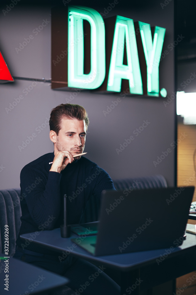 Focused businessman working on a laptop in a modern office