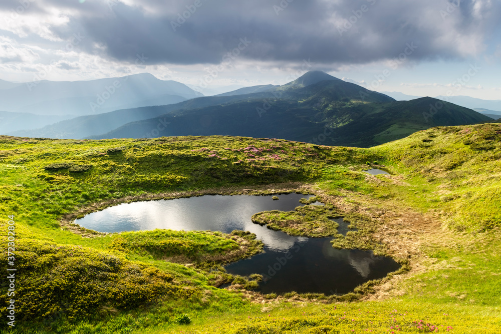 日出时的山湖。绿色的山丘和阳光的如画的夏季景观i