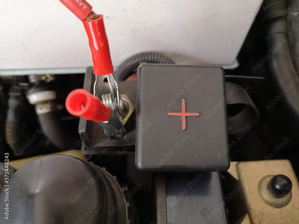 Red clip on car battery positive terminal