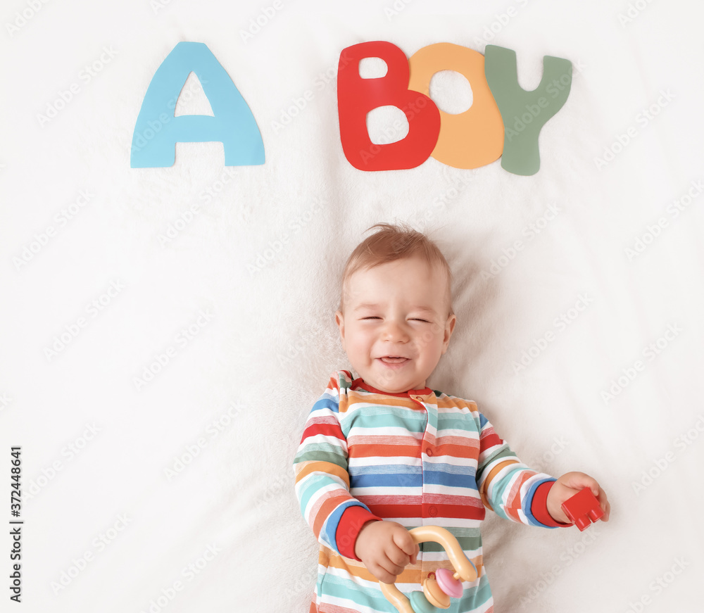 Baby boy lying on the blanket with letters above