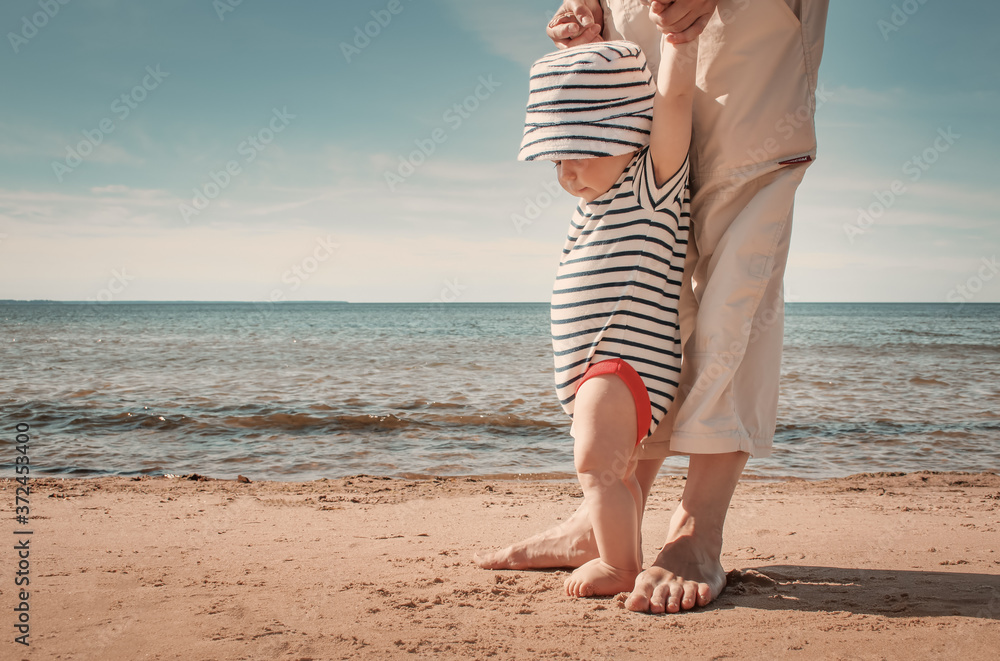 夏日在海滩上散步的小男婴