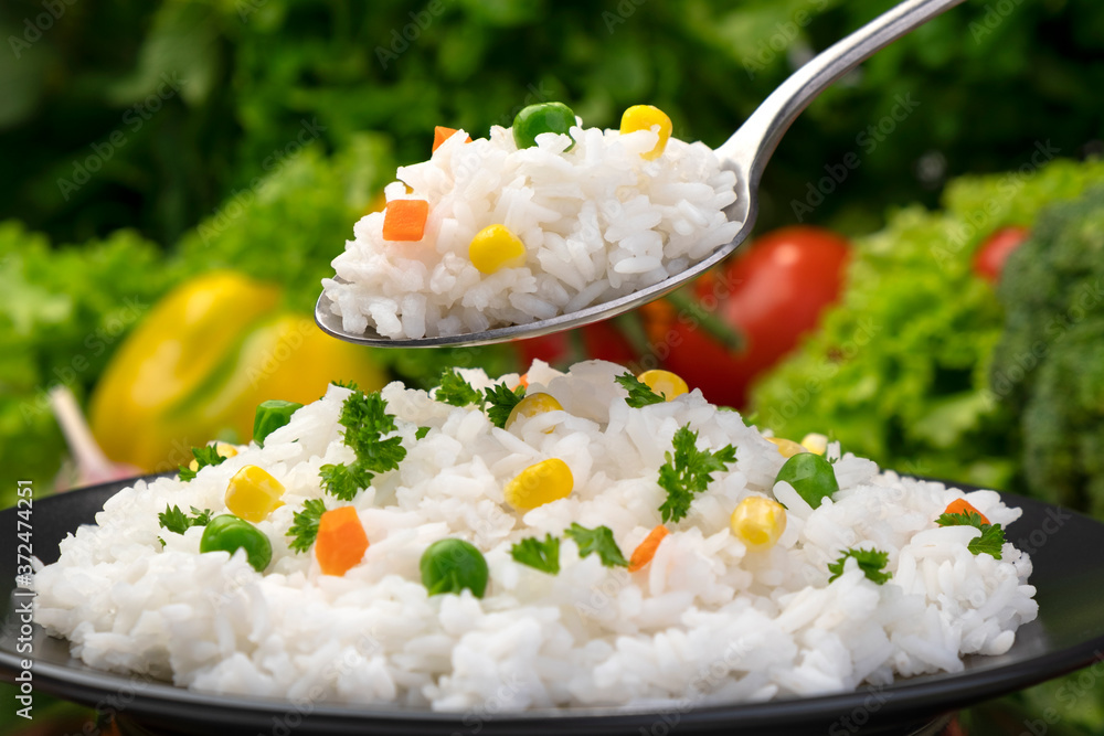 Cooked rice porridge, served with herbs and vegetables on black plate