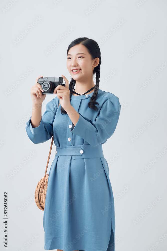 Young asian woman, holding a vintage camera, and trying to take a photo