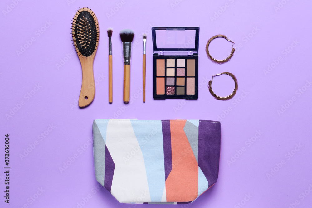 Bag with makeup cosmetics and accessories on color background