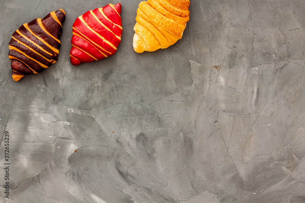 Set of croissants - chocolate, berry, classic - on gray table top view