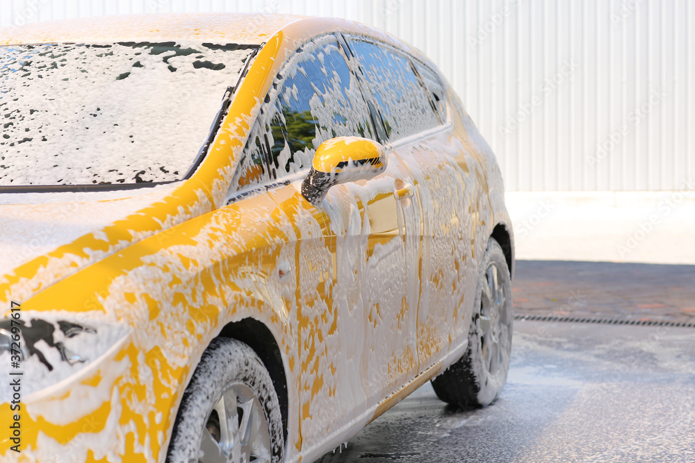 Modern automobile in foam at car wash