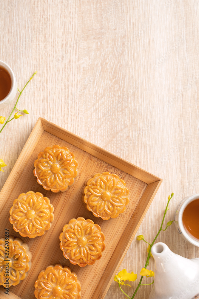 Mid-Autumn Festival holiday concept design of moon cake, mooncakes, tea set on bright wooden table w