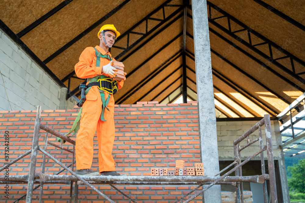 建筑工人在建筑工地上安装砖块。