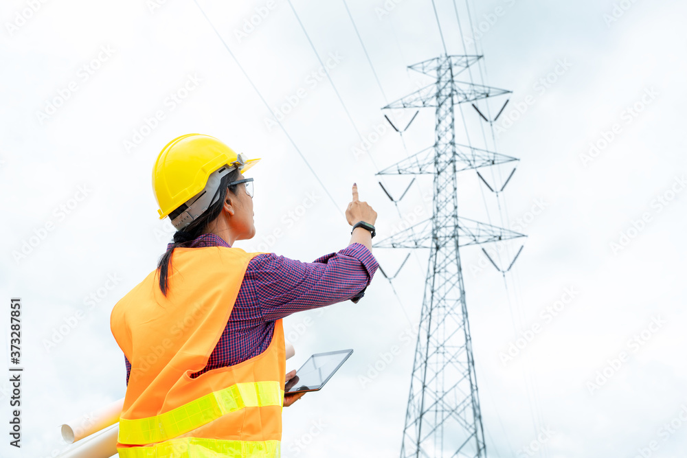 Electrical engineer checking location site near to High voltage tower.