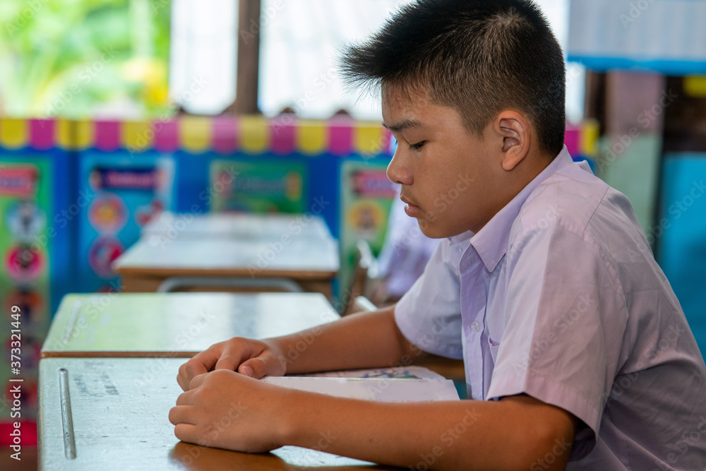 小学生在课堂、教育、学习和人的概念上坐在桌子旁。