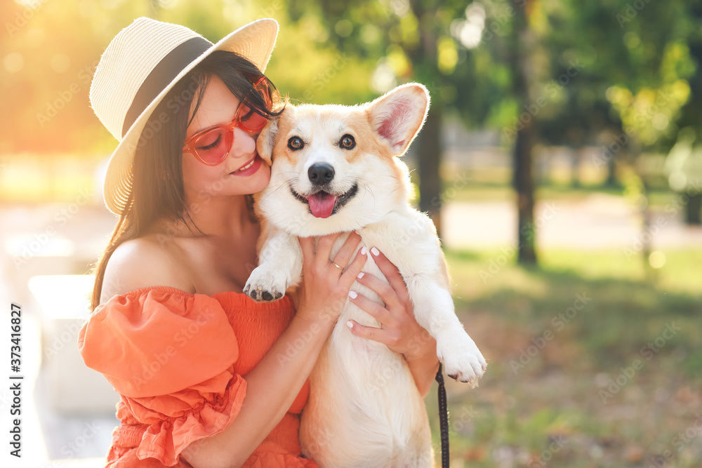 Woman with cute corgi dog walking outdoors