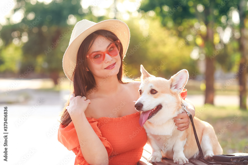 带着可爱的柯基犬在户外散步的女人