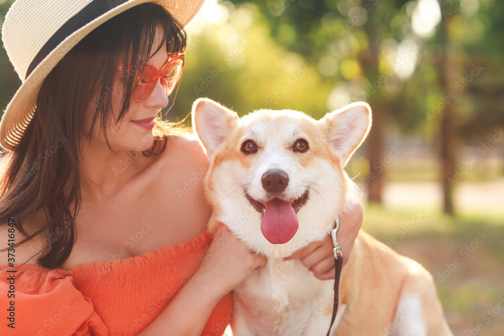 带着可爱的柯基犬在户外散步的女人