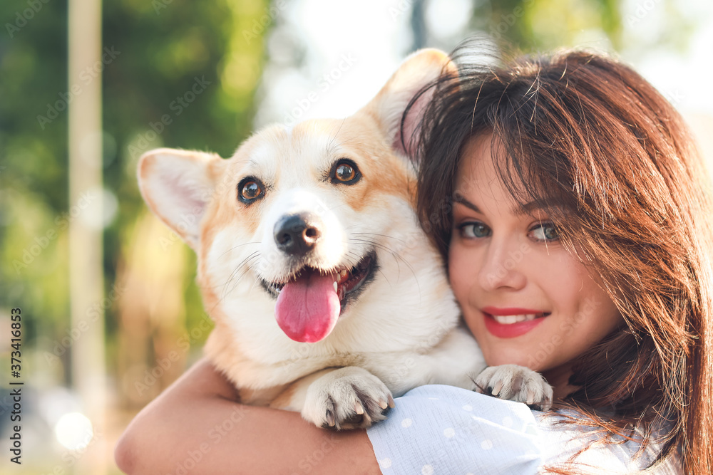 带着可爱的柯基犬在户外散步的女人