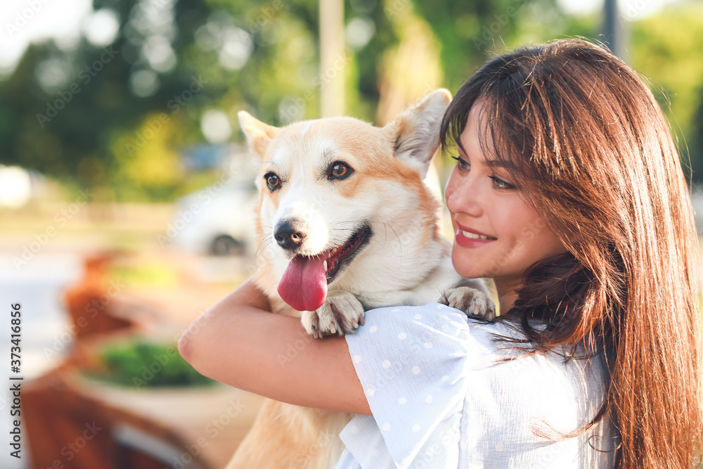 带着可爱的柯基犬在户外散步的女人