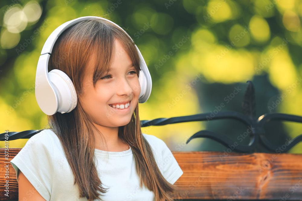 Little girl listening to music in park