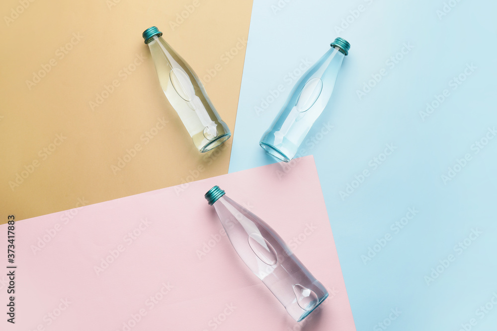 Bottles of clean water on color background