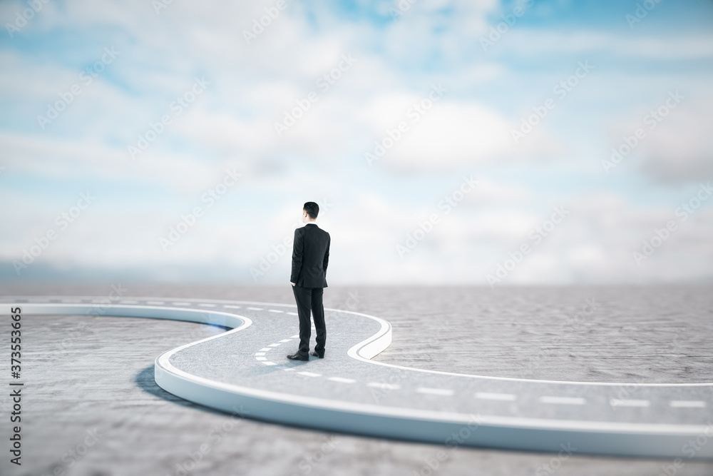 Businessman standing on road and  looks into the distance.