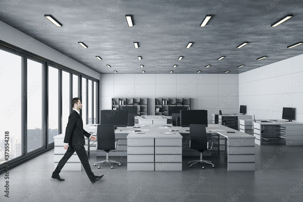 Businessman walking in bright coworking office interior