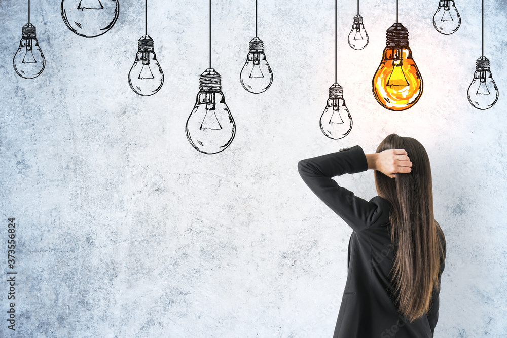 Businesswoman looking on drawing yellow lamps over head.