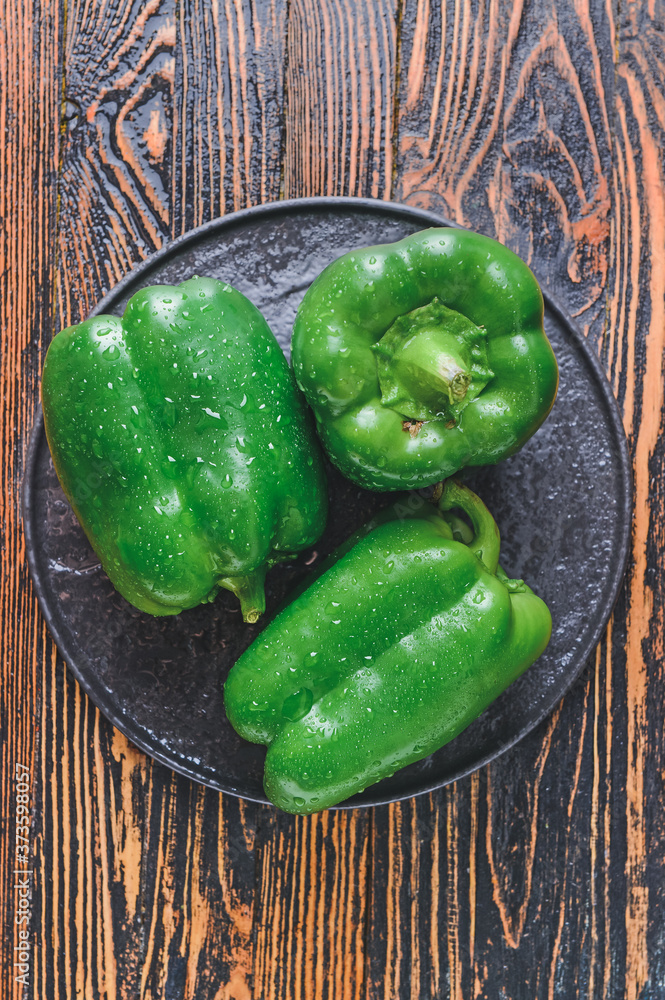 Plate with green bell pepper on table