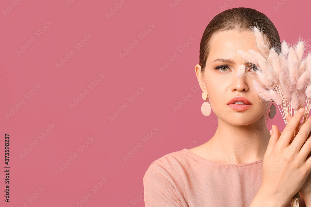 Beautiful young woman wearing stylish jewelry on color background