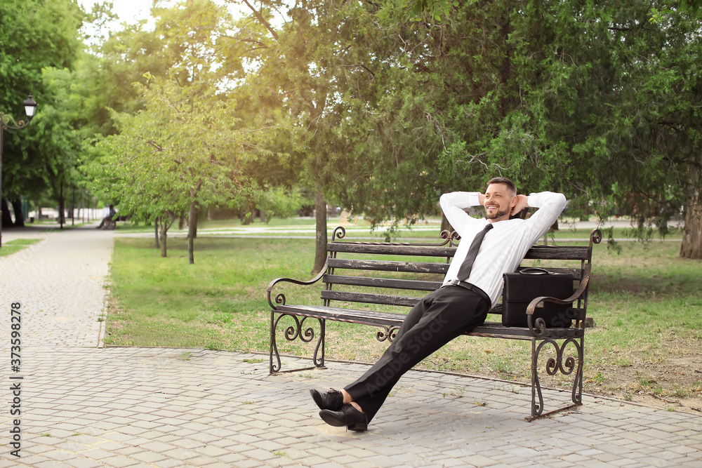 Handsome businessman relaxing in park