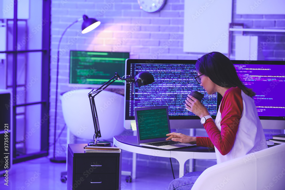 Female programmer working in office at night