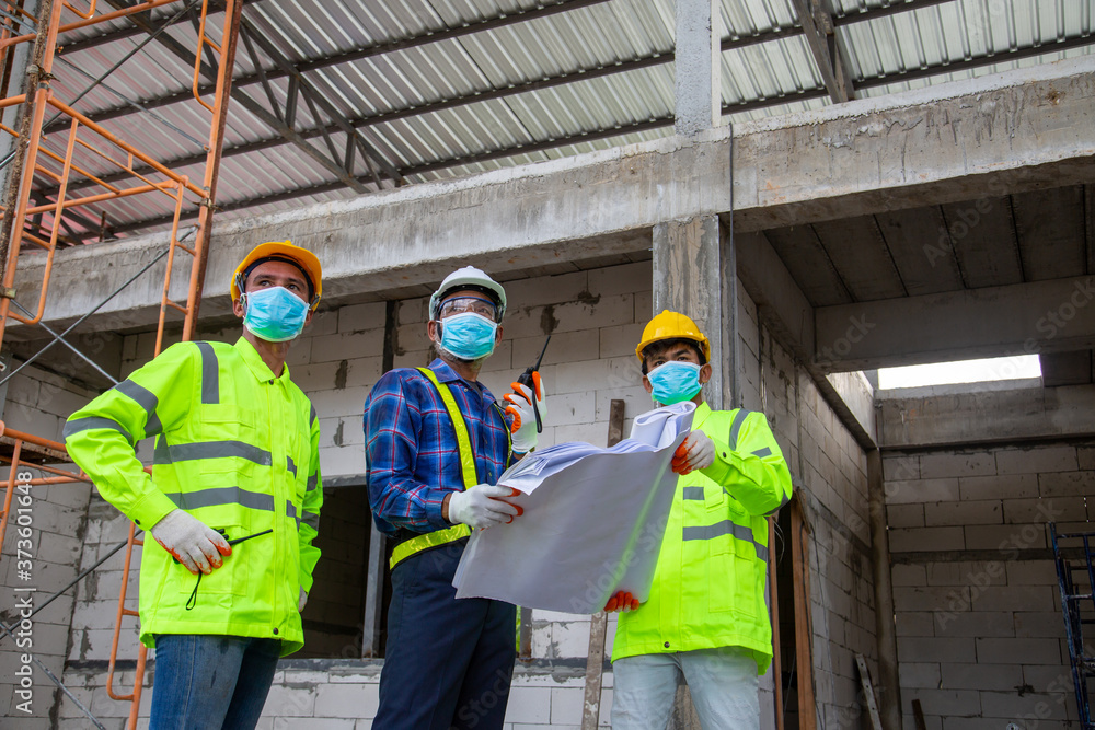 亚洲工程师技术团队介绍并监督工人在施工中建造房屋