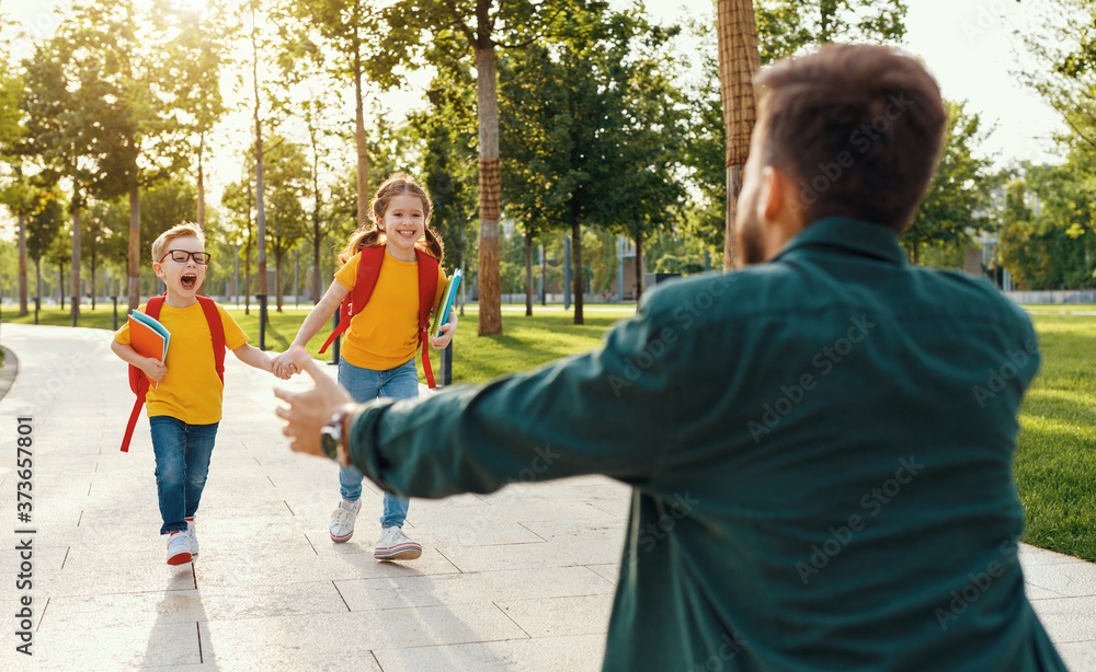 Father meets children running into his arms after school.