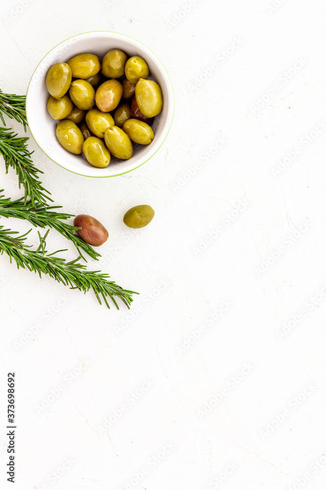 Appetizer. Green and black olives in bowl, rosemary top view space for text