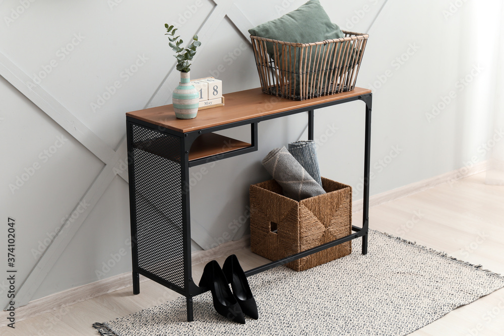 Table with accessories near grey wall in room