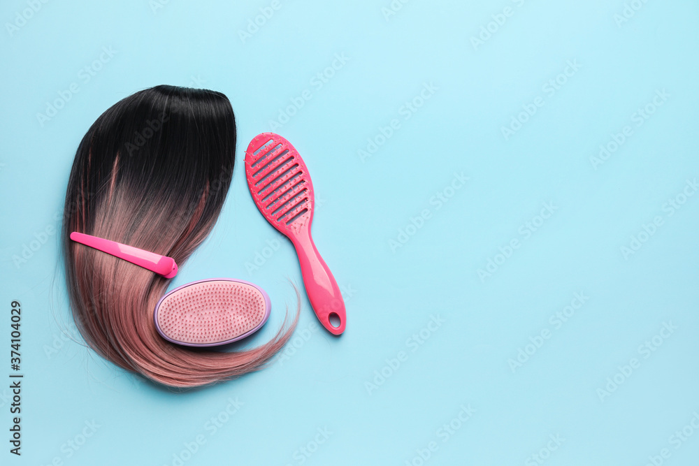 Unusual wig with hairdresser supplies on color background