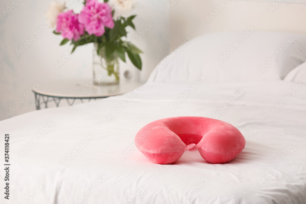 Travel pillow on bed in room