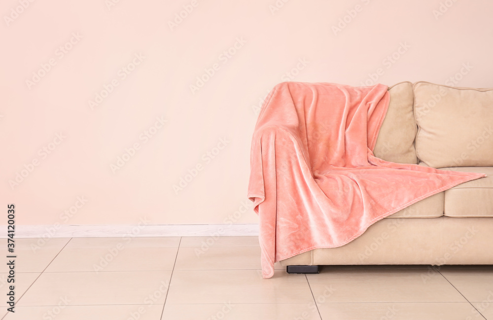 Soft sofa near color wall in room