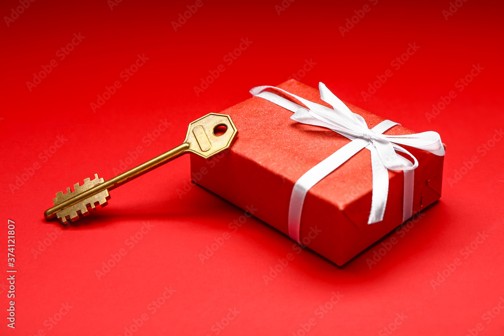 Gift box with key on color background