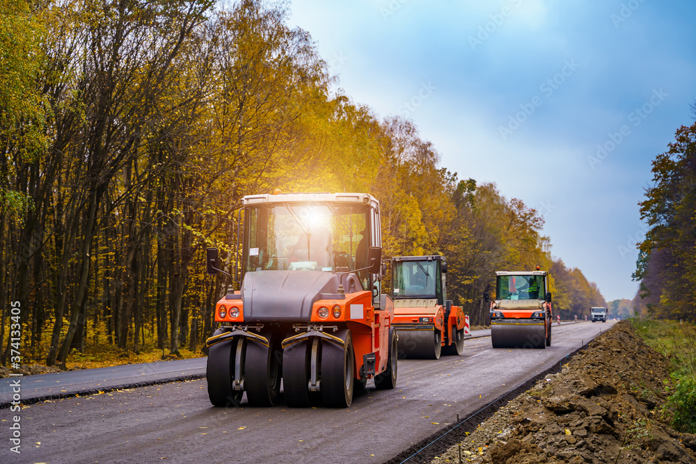 三台压路机正在平整新沥青。新道路。新铺设的沥青。