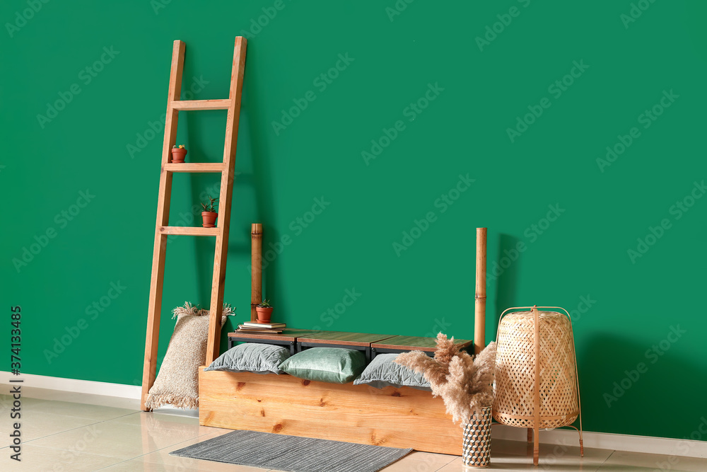 Wooden stand with decor near color wall in room