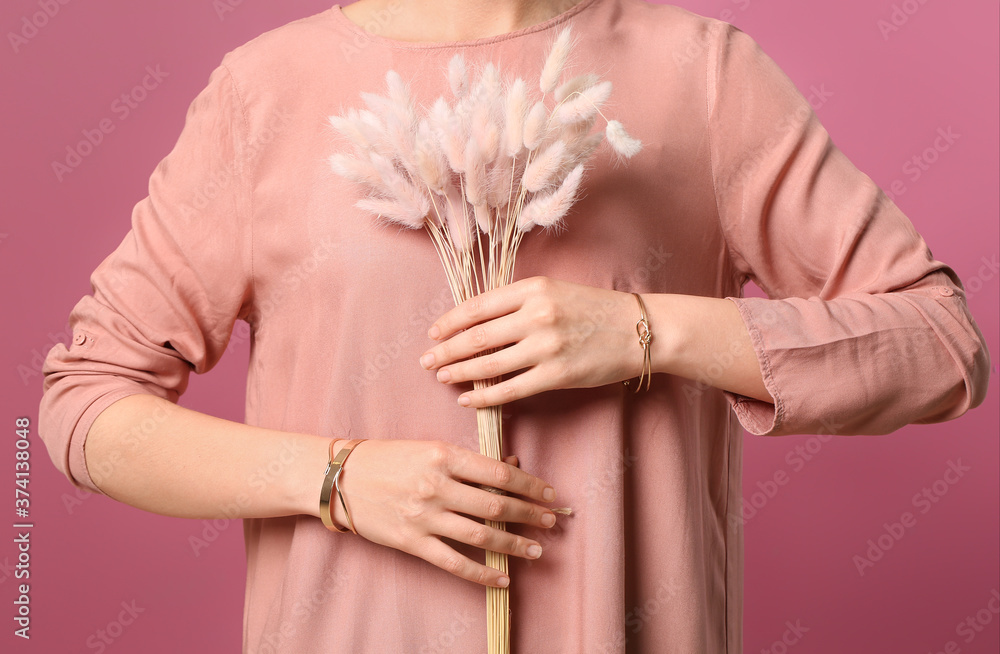 Beautiful young woman wearing stylish jewelry on color background