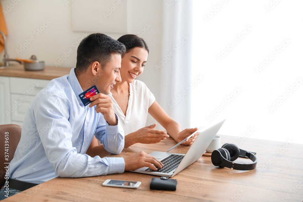 Young couple booking tickets and room in hotel online at home