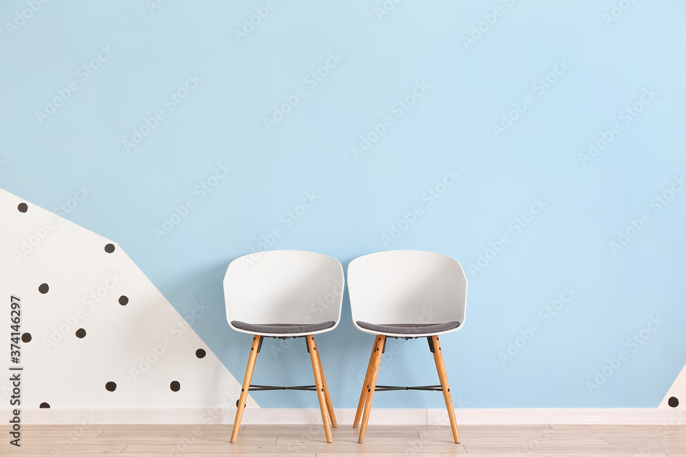 Modern chairs near color wall