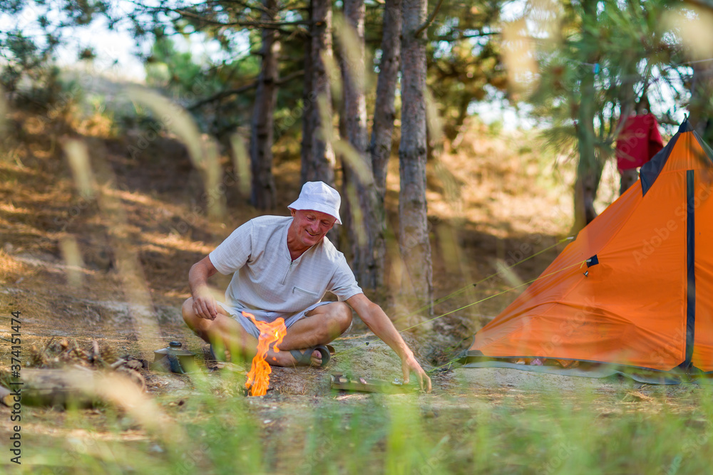 A tourist throws small chips into the fire.