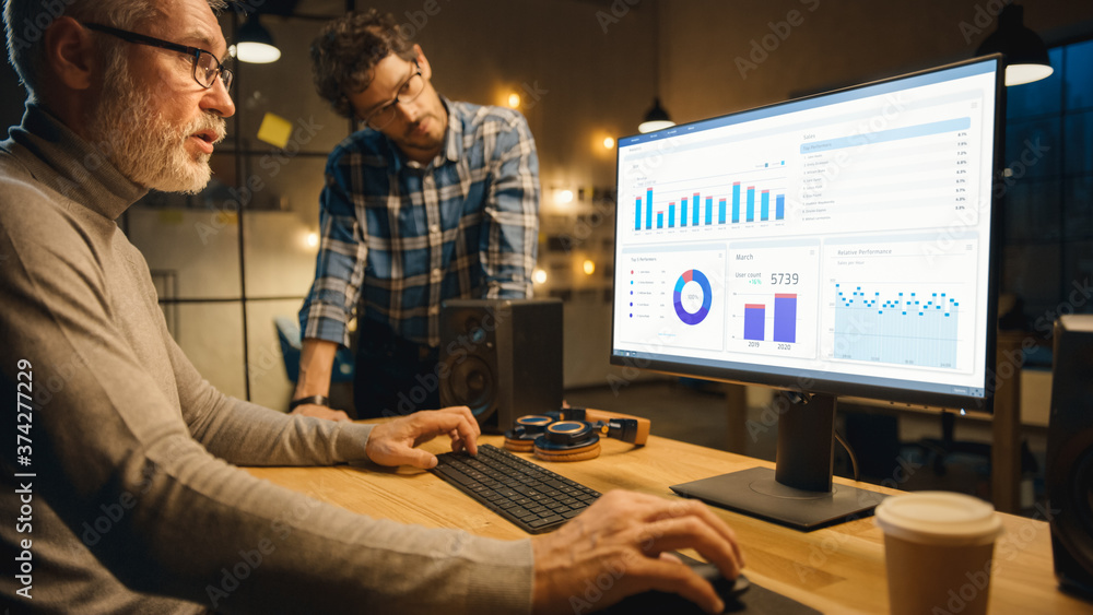 Professional Senior Business Martket Analyst Works on Desktop Computer Working with Charts, Graphs, 