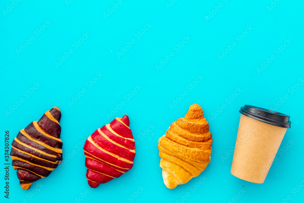 Coffee and croissants on blue table top view