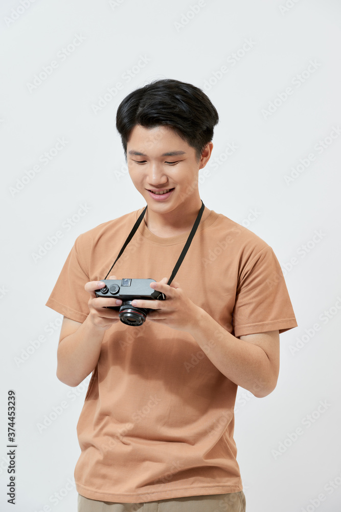 Attractive handsome young Asian man using camera over white background.