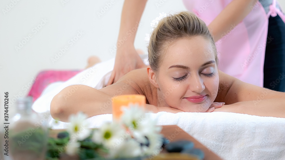 Relaxed woman getting back massage in luxury spa with professional massage therapist. Wellness, heal