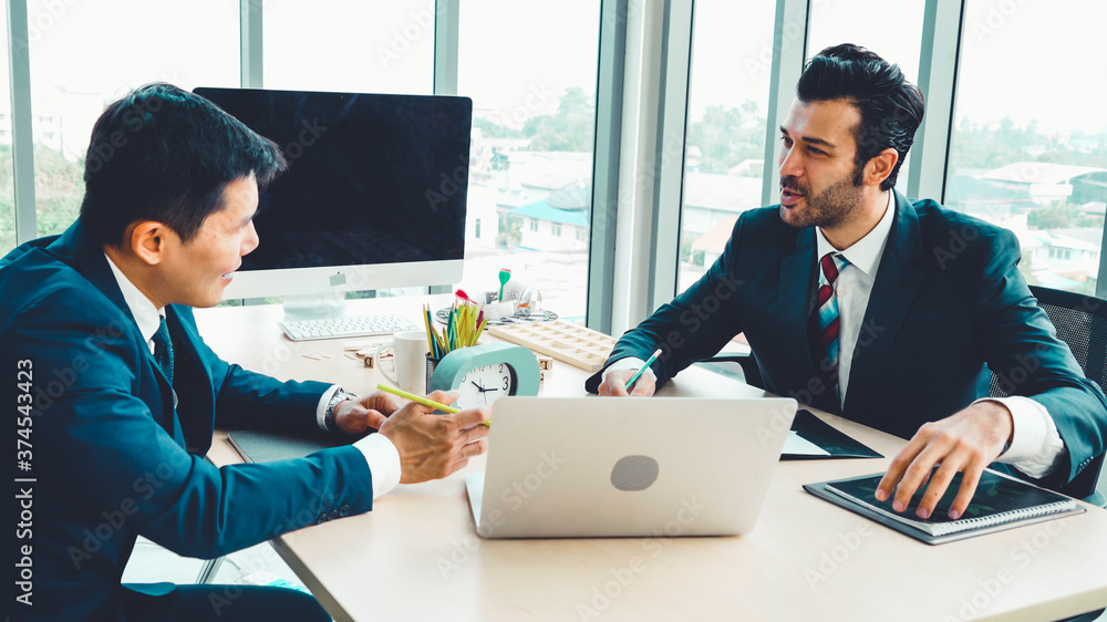 Two business people talk project strategy at office meeting room. Businessman discuss project planni